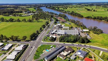 An industrial area with warehouses, a parking lot, and a river.