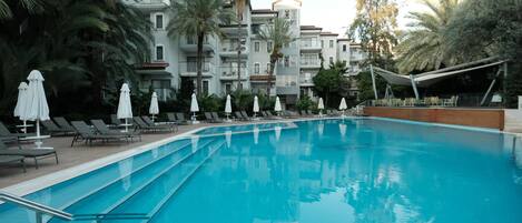 Piscine extérieure, parasols de plage, chaises longues