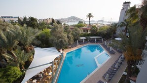 Una piscina en la azotea con tumbonas y vistas al mar.