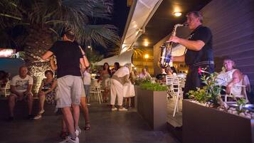 An outdoor patio area with seating and a live band performance.