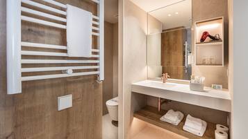 Ein modernes Badezimmer mit einem Holzkosmetikschrank, einem großen Spiegel und einem Handtuchhalter.