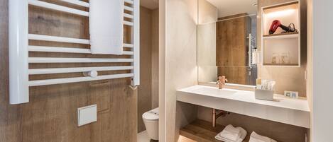 Ein modernes Badezimmer mit einem Holzkosmetikschrank, einem großen Spiegel und einem Handtuchhalter.