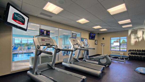 A gym with treadmills, a rowing machine, and a weight bench. - TownePlace Suites by Marriott Joliet South (Joliet)