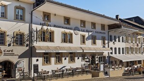 Um edifício com café, restaurante e pizzaria no andar térreo.