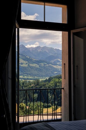 A room with a large window offering a view of a mountainous landscape. - Le Saint Georges (Gruyeres)