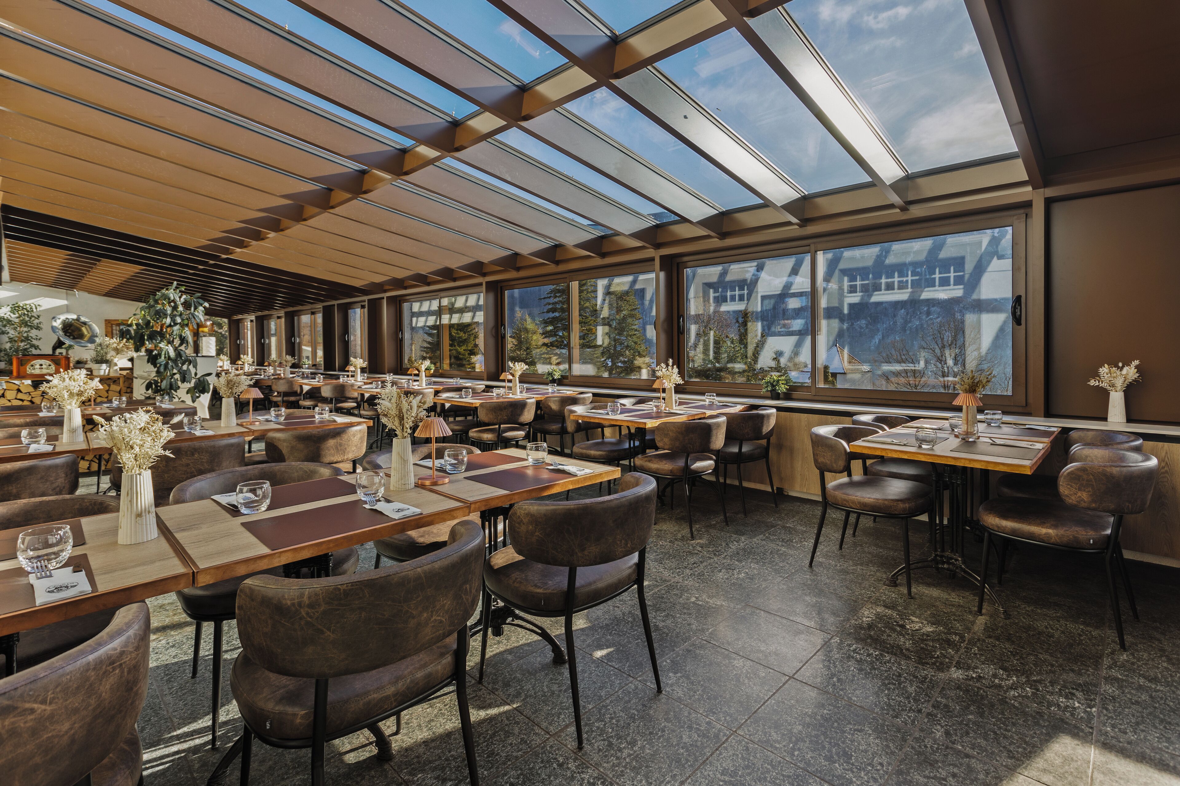 Ein geräumiges Restaurant mit hohen Decken, großen Fenstern und moderner Einrichtung.