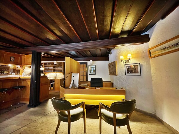 A bar area with wooden furniture, a counter, and a desk with a computer.