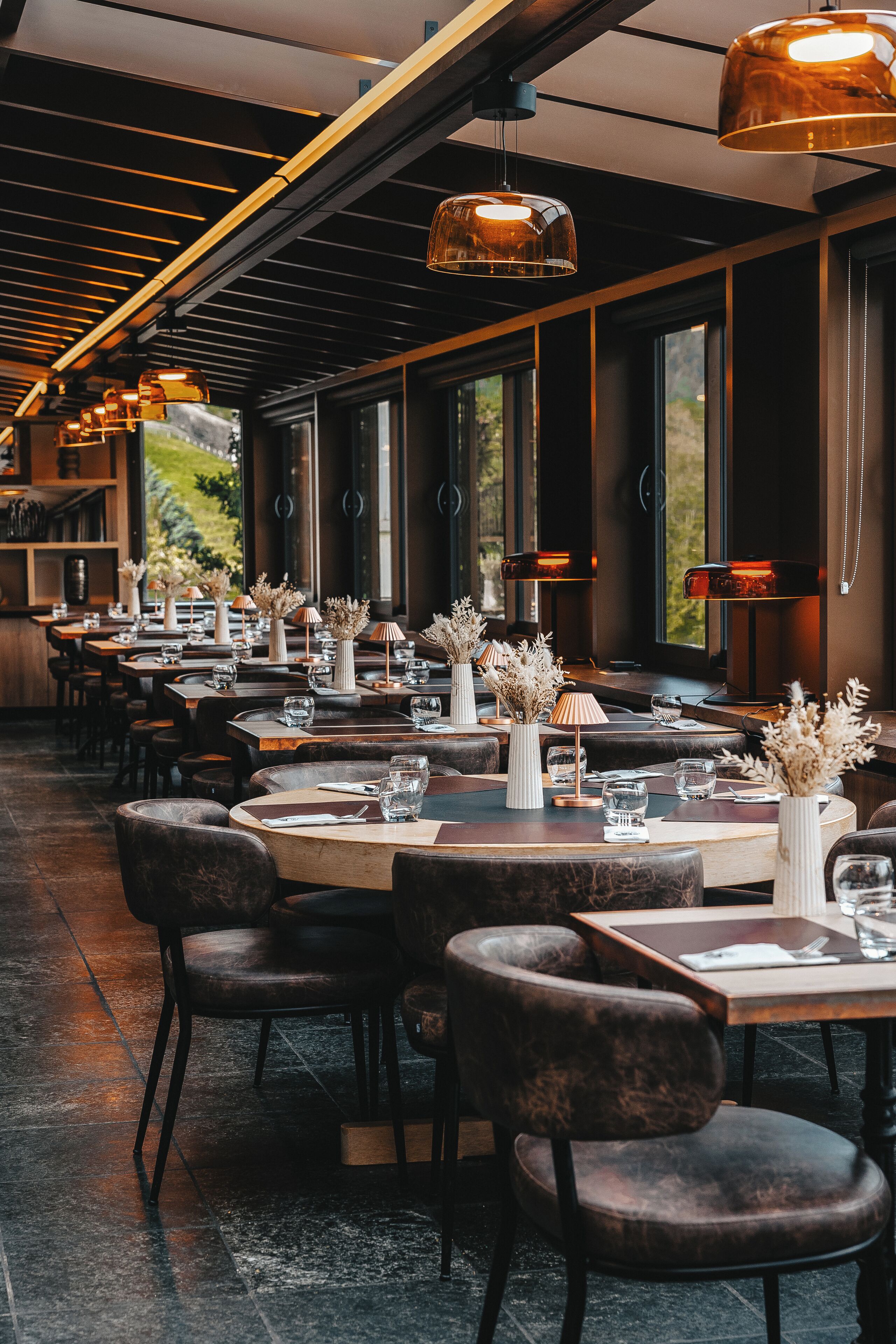 Un restaurant doté d’une grande salle à manger, de nombreuses tables et de chaises.