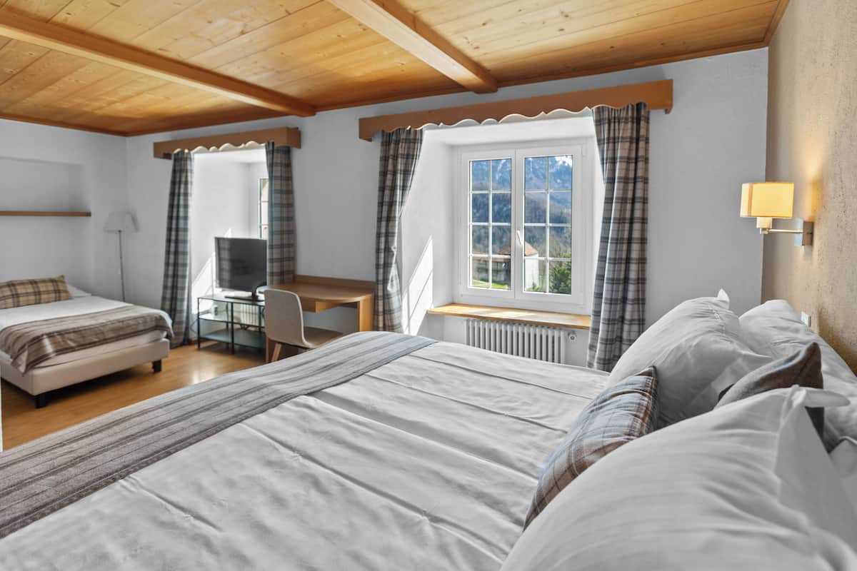 A bedroom with a bed, a desk, and a chair.