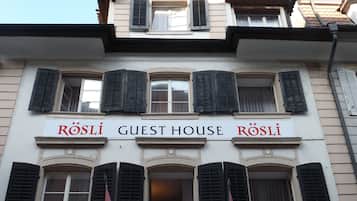 A building with a sign reading "RÖSLI GUEST HOUSE".