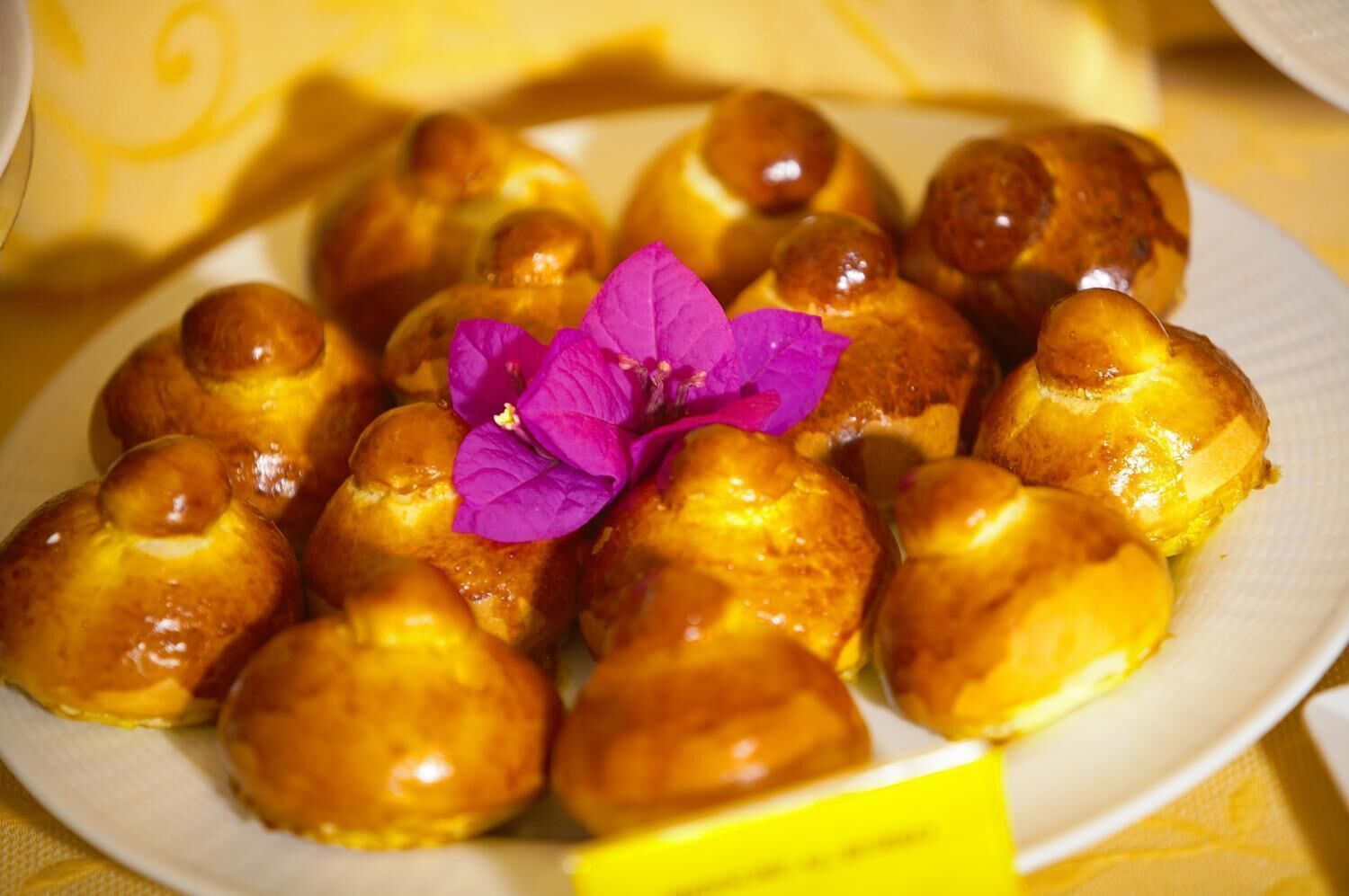 A plate of heart-shaped pastries with a purple flower garnish.