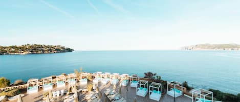 Un hotel frente al mar con terraza y vistas al océano.