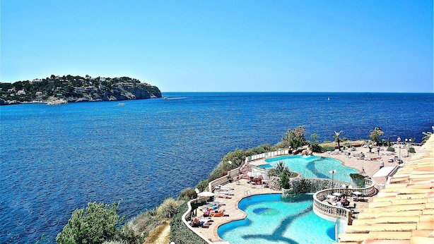 Un resort con una gran piscina, playa y vista al mar.