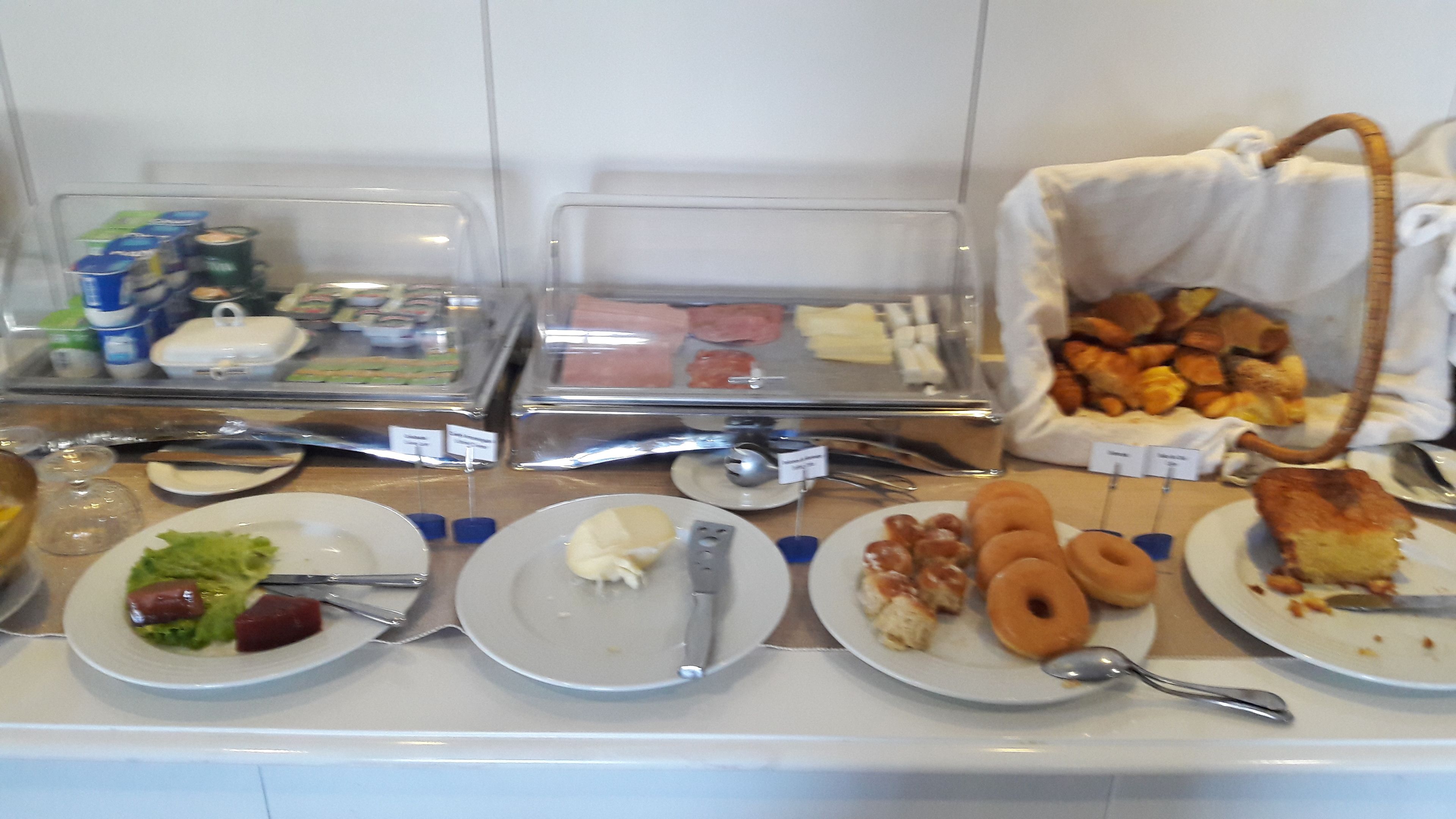 A buffet with various food items including salads, meats, and pastries.