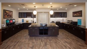 A spacious kitchen with dark cabinetry, a central island, and pendant lighting. - Homewood Suites by Hilton San Antonio North (San Antonio)