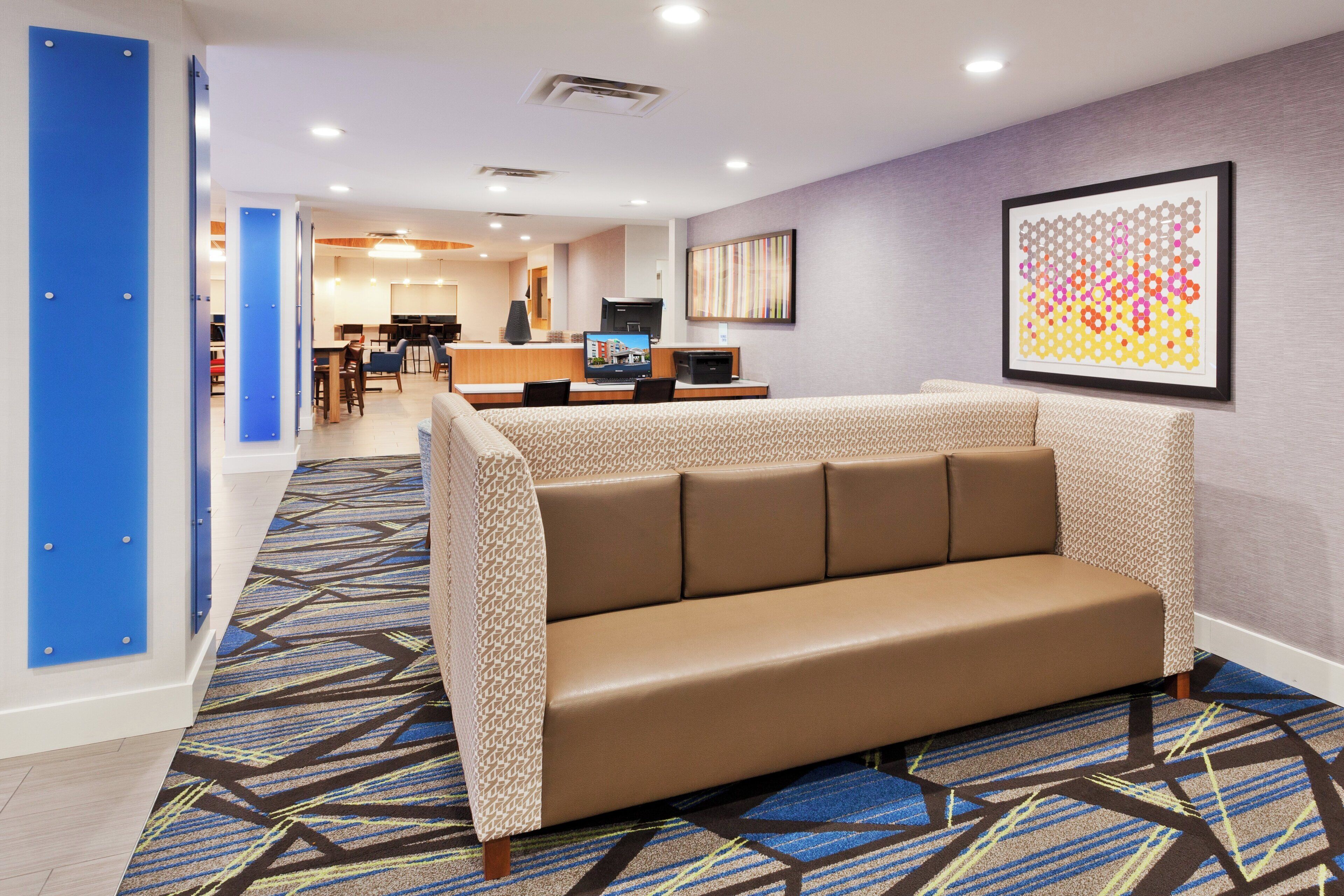 Un hall de hotel con una zona de estar, una recepción y un comedor.