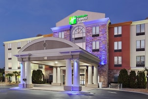 Edificio de Holiday Inn Express & Suites con entrada cubierta, columnas y fachada de piedra.