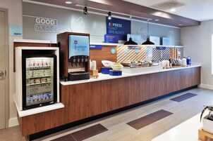 Espaço de café da manhã com geladeira, dispensador de suco e diversas opções de alimentos.