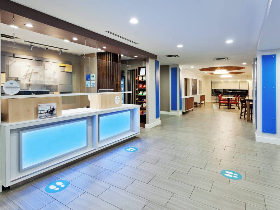 A reception area with a counter, seating, and a view into the dining area.