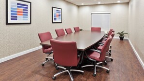 A conference room with a long table, red chairs, and two framed color charts on the walls. - Holiday Inn Express & Suites Rome-East by IHG (Rome)