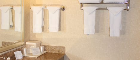 Un baño con lavamanos, inodoro y toallero.