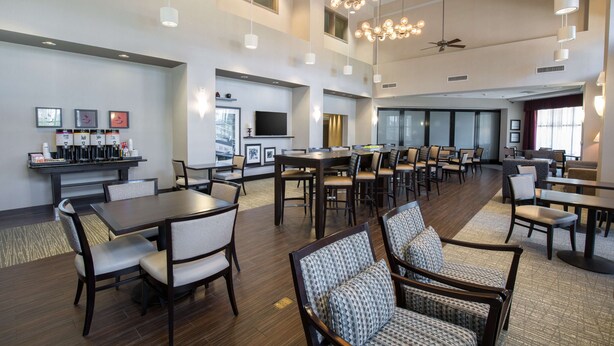 A spacious hotel lobby with multiple seating areas, a coffee station, and a television. - Hampton Inn & Suites San Diego-Poway (Poway)