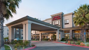 A hotel with a covered entrance, palm trees, and a clear sky. - Hampton Inn & Suites San Diego-Poway (Poway)