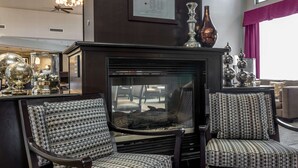 A modern living room with a fireplace, patterned chairs, decorative vases, and a ceiling fan. - Hampton Inn & Suites San Diego-Poway (Poway)