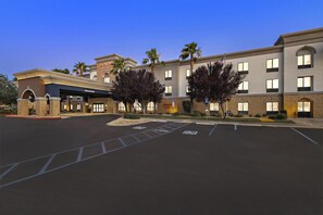 A hotel with a parking lot, handicap parking, and a clear sky. - Hampton Inn & Suites Lancaster (Lancaster)