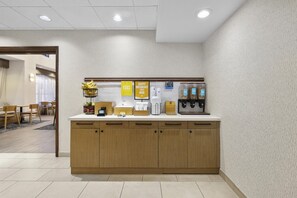 A hotel room with a kitchenette, a dining area with chairs, and a view of the hallway. - Hampton Inn & Suites Lancaster (Lancaster)