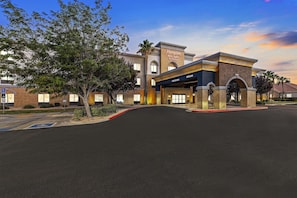 A hotel entrance with a clear sign, a parking area, and a landscaped driveway. - Hampton Inn & Suites Lancaster (Lancaster)