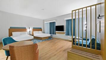 A hotel room with two beds, a TV, a desk, and a chair.