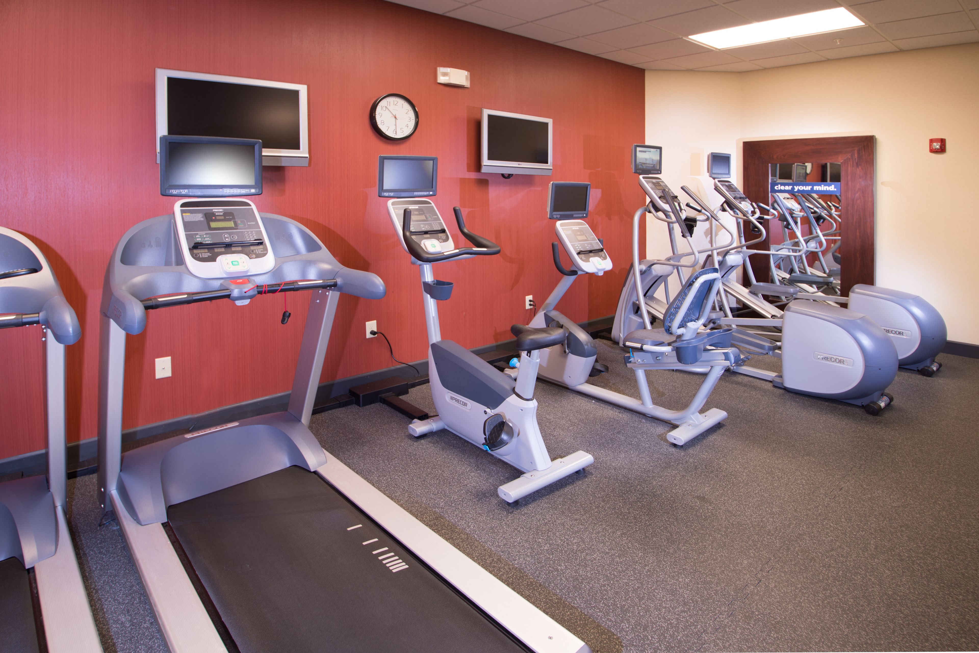A fitness center with treadmills, elliptical machines, and stationary bikes.