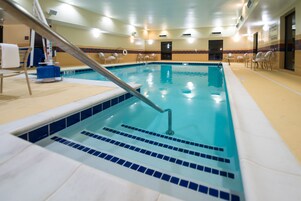 Una piscina techada, sillones reclinables de piscina