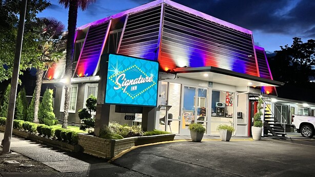 A Signature Inn with a modern design, featuring a prominent neon sign, large windows, and a well-maintained exterior. - Signature Inn Eugene (Eugene)