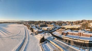 Un paisaje nevado con un gran complejo de edificios, que incluye un hotel de varios pisos y un área de estacionamiento.