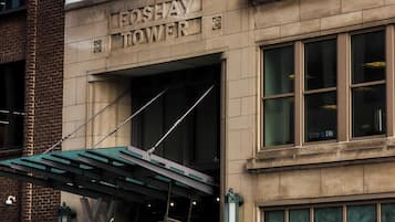 The Foshay Tower building with a brick facade, a marquee sign, and multiple flags including the American flag.