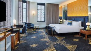 Ein Hotelzimmer mit Bett, Schreibtisch, Stuhl und einem großen Fenster.