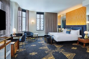 Ein Hotelzimmer mit Bett, Schreibtisch, Stuhl und einem großen Fenster.