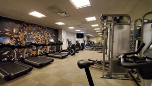 Ein Fitnessstudio mit Laufbändern, Crosstrainern und Gewichten.