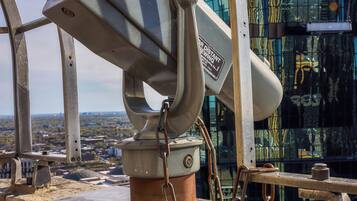 Un telescopio montado en una estructura con vista a una ciudad.