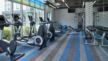 A gym with treadmills, elliptical machines, and weightlifting equipment.
