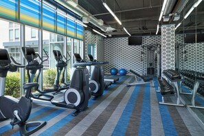 A gym with treadmills, elliptical machines, and weightlifting equipment. - Aloft by Marriott Las Colinas (Irving)