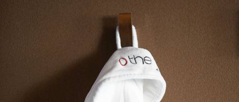 A white towel with a red logo hanging on a brown wall.