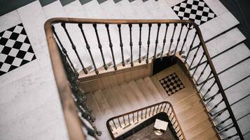 A staircase with a checkered floor pattern and a metal handrail.