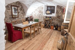 Une cave rustique avec des meubles en bois, des murs en pierre et des bouteilles de vin.
