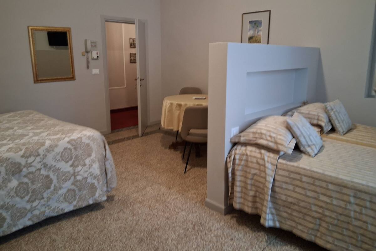 Une chambre avec deux lits, un bureau et une chaise.