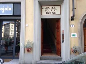 Entrada de un hotel con un cartel que dice "HOTEL TOURIST HOUSE".
