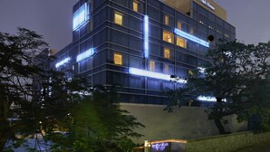 Un hotel de varios pisos con letreros iluminados y ventanas.