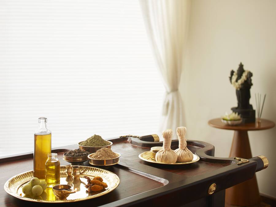 A tray with various items including a bottle of oil, spices, and fruits.